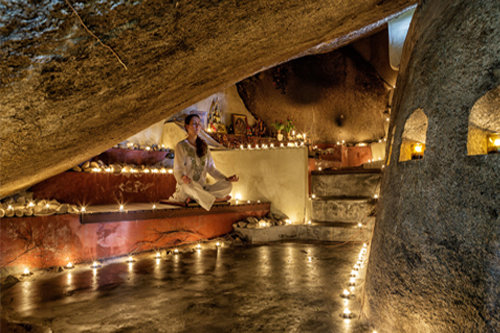 a woman meditating in a flame lit environment