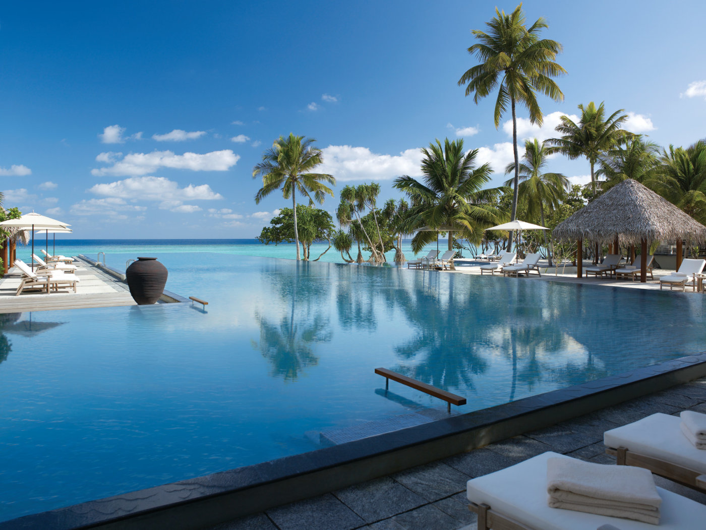 a pool in a resort with a distant sea