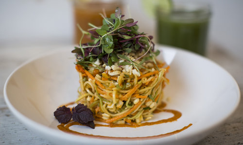 salad with green leaves and carrot on a white plate