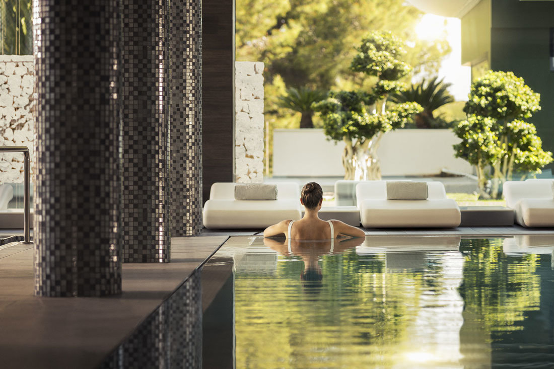 a woman half submerged in a pool of a resort