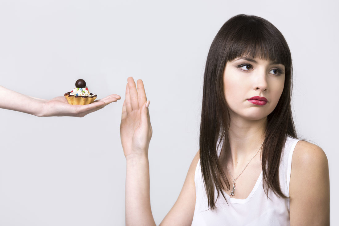 a woman saying no to a cake