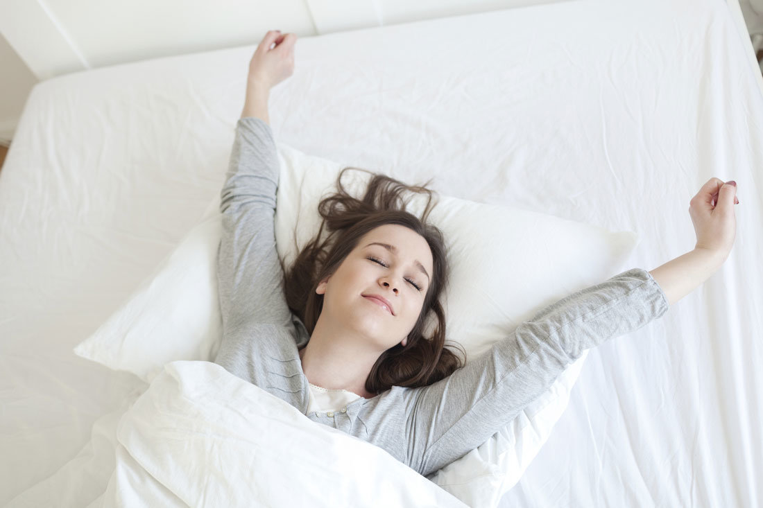 a woman in bed just about to wake up