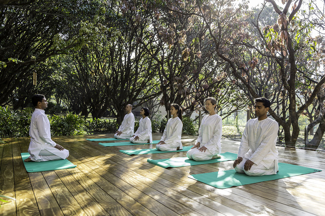 5 people meditating while the instructor sits in front